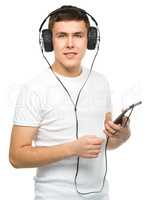 Young man enjoying music using headphones