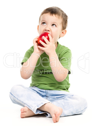 Portrait of a cute little boy with red apple