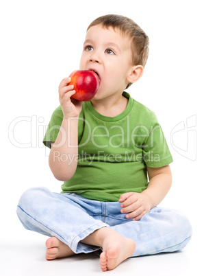 Portrait of a cute little boy with red apple