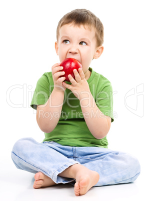 Portrait of a cute little boy with red apple