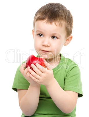 Portrait of a cute little boy with red apple