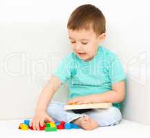 Boy is playing with puzzle