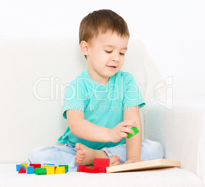 Boy is playing with puzzle