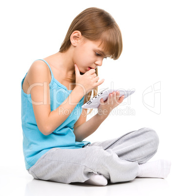 Young girl is using tablet while sitting on floor