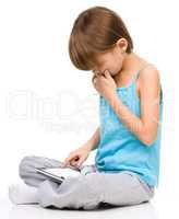 Young girl is using tablet while sitting on floor