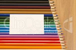 Blank white paper and colored pencil on wooden background