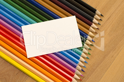 Blank white paper and colored pencil on wooden background