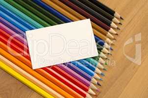 Blank white paper and colored pencil on wooden background