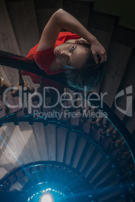 pretty woman in red dress on the old stairs