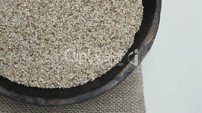 Sesame seeds in rustic wooden bowl on sackcloth Background