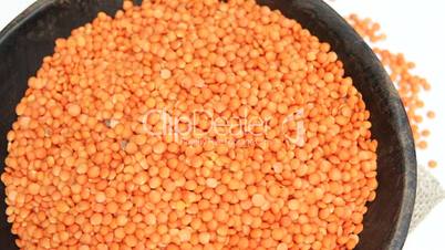 Red lentils in rustic wooden bowl on sackcloth Background