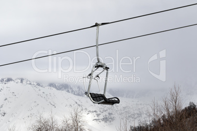 Chair lift and snowy mountains in haze