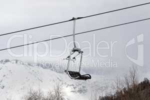 Chair lift and snowy mountains in haze