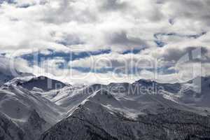 View on snowy mountains and cloudy sky in evening