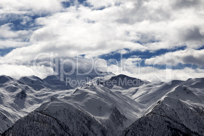 View on snowy mountains and cloudy sky at evening