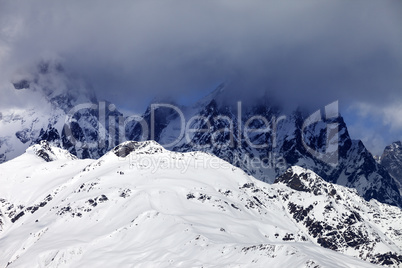 Snowy rocks in haze and storm clouds before blizzard