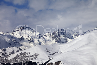 Snowy off-piste slope and mountains in clouds