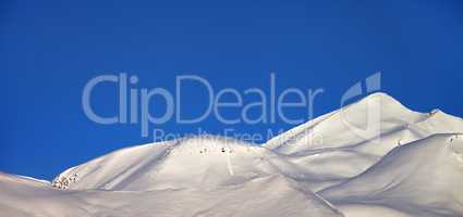 Panoramic view on off-piste slope and blue clear sky in morning