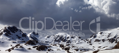 Panoramic view on snowy mountains in clouds