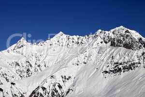 Snowy mountains and blue clear sky at sun day