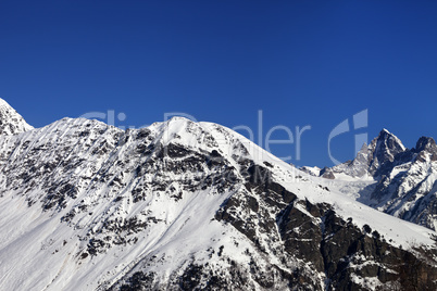 Snowy mountains and blue clear sky at nice sun day