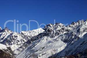View on snowy rocks and blue clear sky at nice sun day