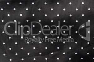 black fabric background with white dots