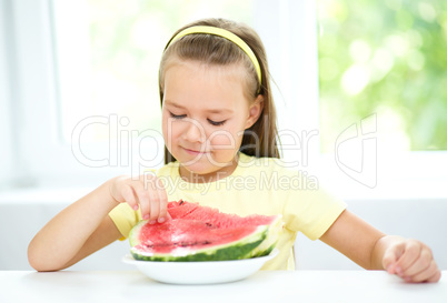 Cute little girl is eating watermelon