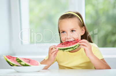 Cute little girl is eating watermelon