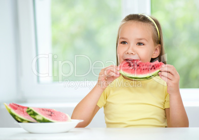 Cute little girl is eating watermelon