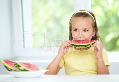 Cute little girl is eating watermelon