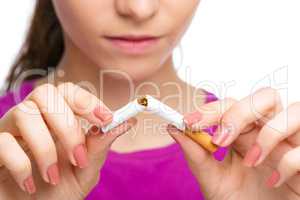 Young woman is breaking a cigarette