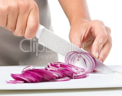 Cook is chopping onion