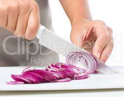 Cook is chopping onion