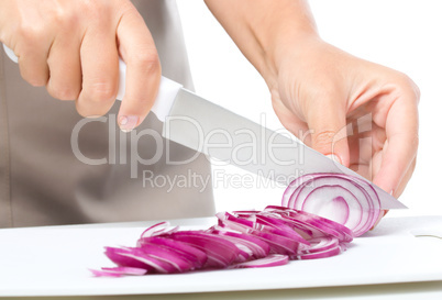 Cook is chopping onion