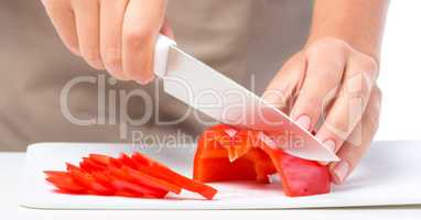 Cook is chopping bell pepper