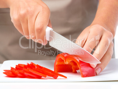 Cook is chopping bell pepper