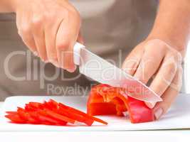 Cook is chopping bell pepper