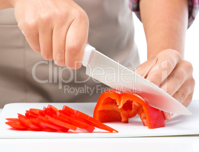 Cook is chopping bell pepper