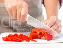 Cook is chopping bell pepper