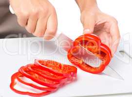 Cook is chopping bell pepper