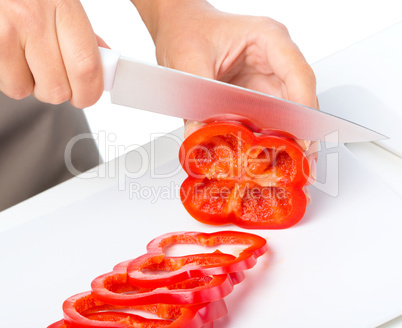 Cook is chopping bell pepper