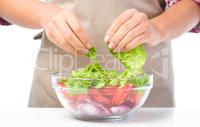 Cook is tearing lettuce while making salad