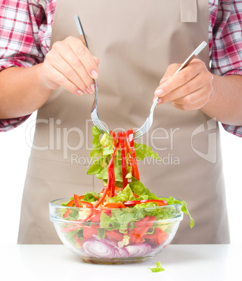 Cook is mixing salad