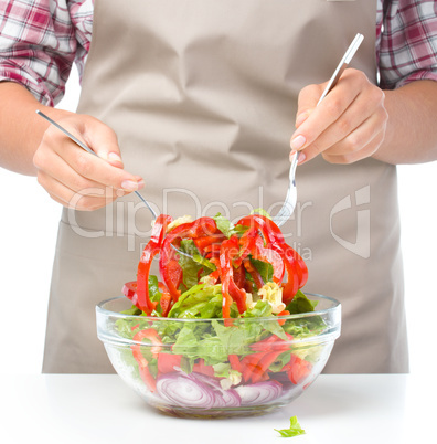 Cook is mixing salad