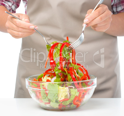 Cook is mixing salad