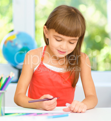 Little girl is drawing using pencils