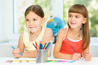 Little girls are drawing using pencils