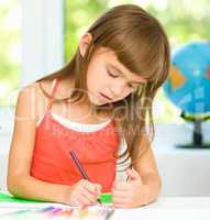 Little girl is drawing using pencils