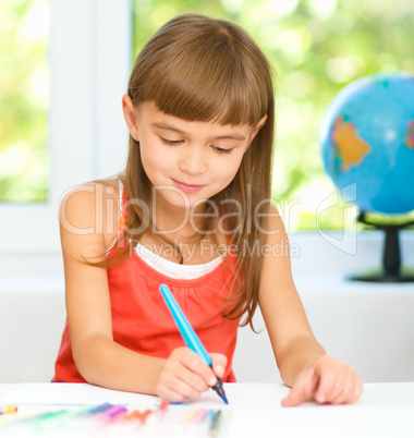 Little girl is drawing using pencils